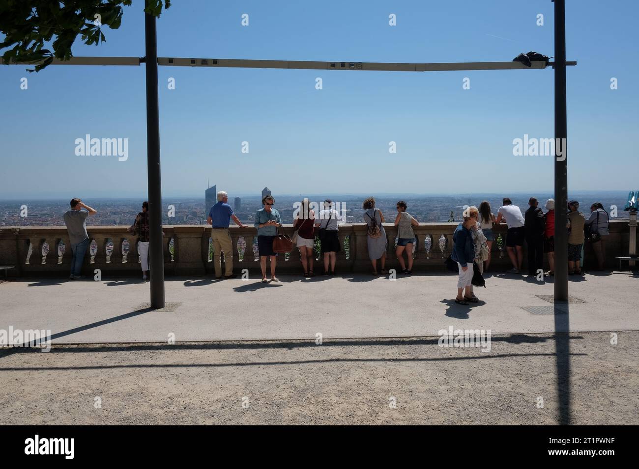 Die Menschen stehen und lehnen sich gegen die schwere Balustrade an einem Aussichtspunkt mit einem weiten, offenen Blick auf Lyon von der Basilika Notre Dame de Fourvière Stockfoto