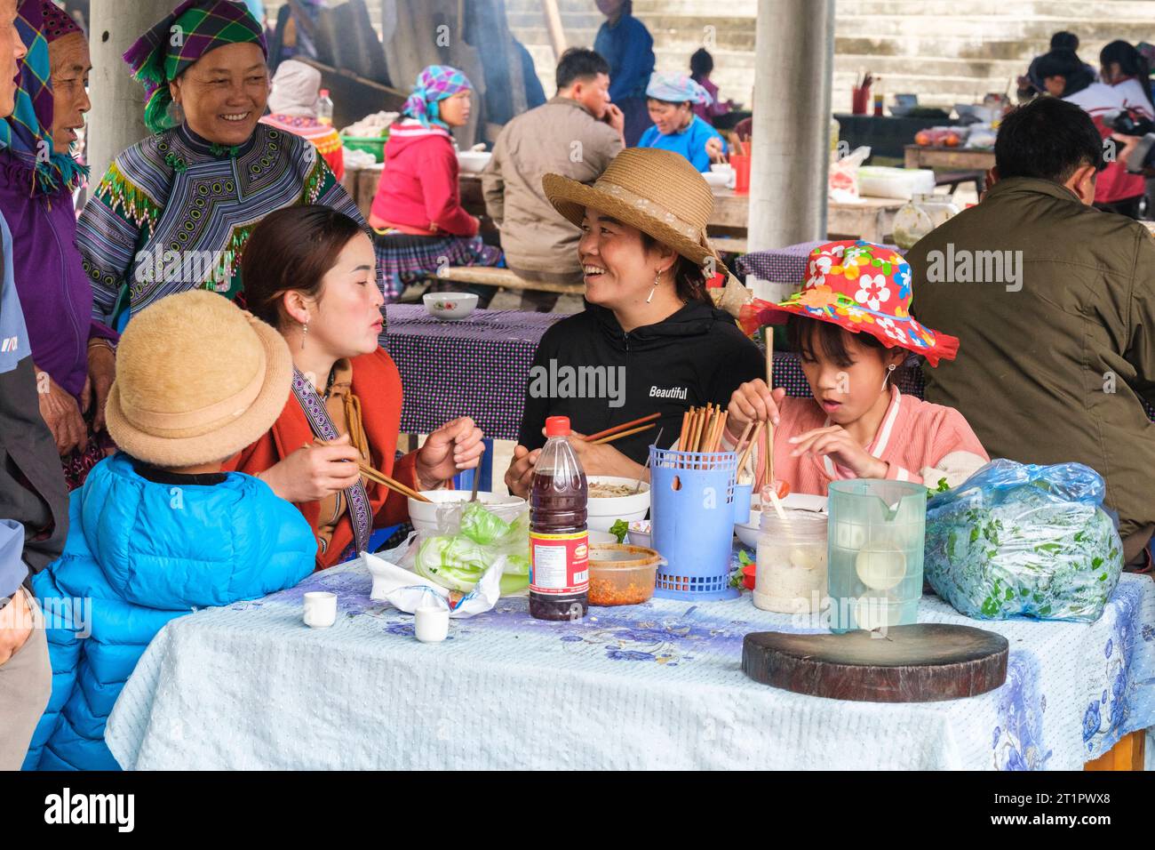 Cau Marktszene, Vietnam. Hmong-Frauen reden während des Mittagessens. Provinz Lao Cai. Stockfoto