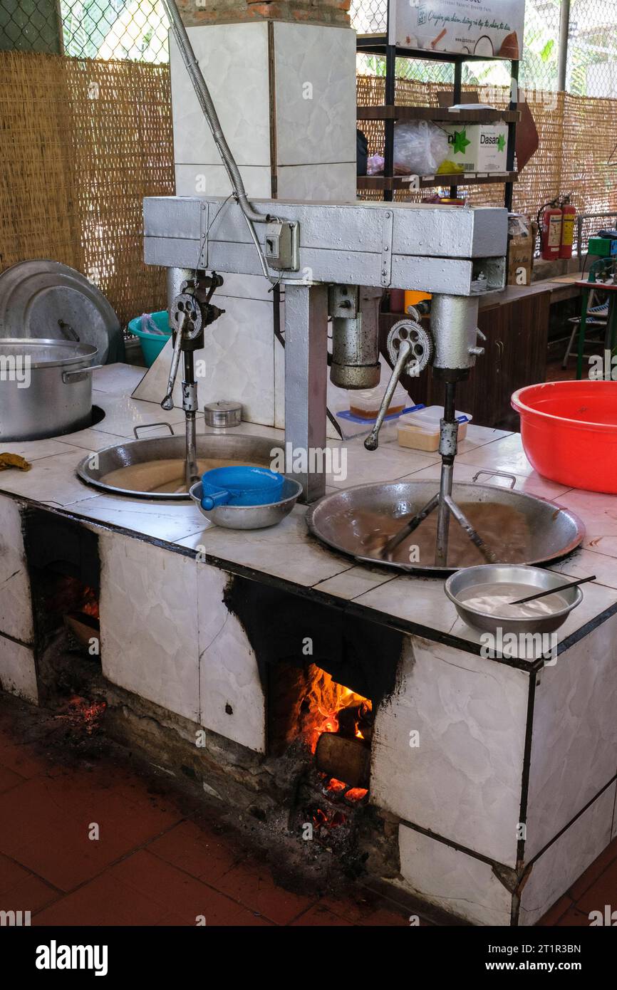 Coconut Candy Factory, Vietnam, zwischen Ho Chi Minh und Can Tho. Kokosmischung über Feuer rühren, mit Kokosnussschalen angetrieben. Stockfoto