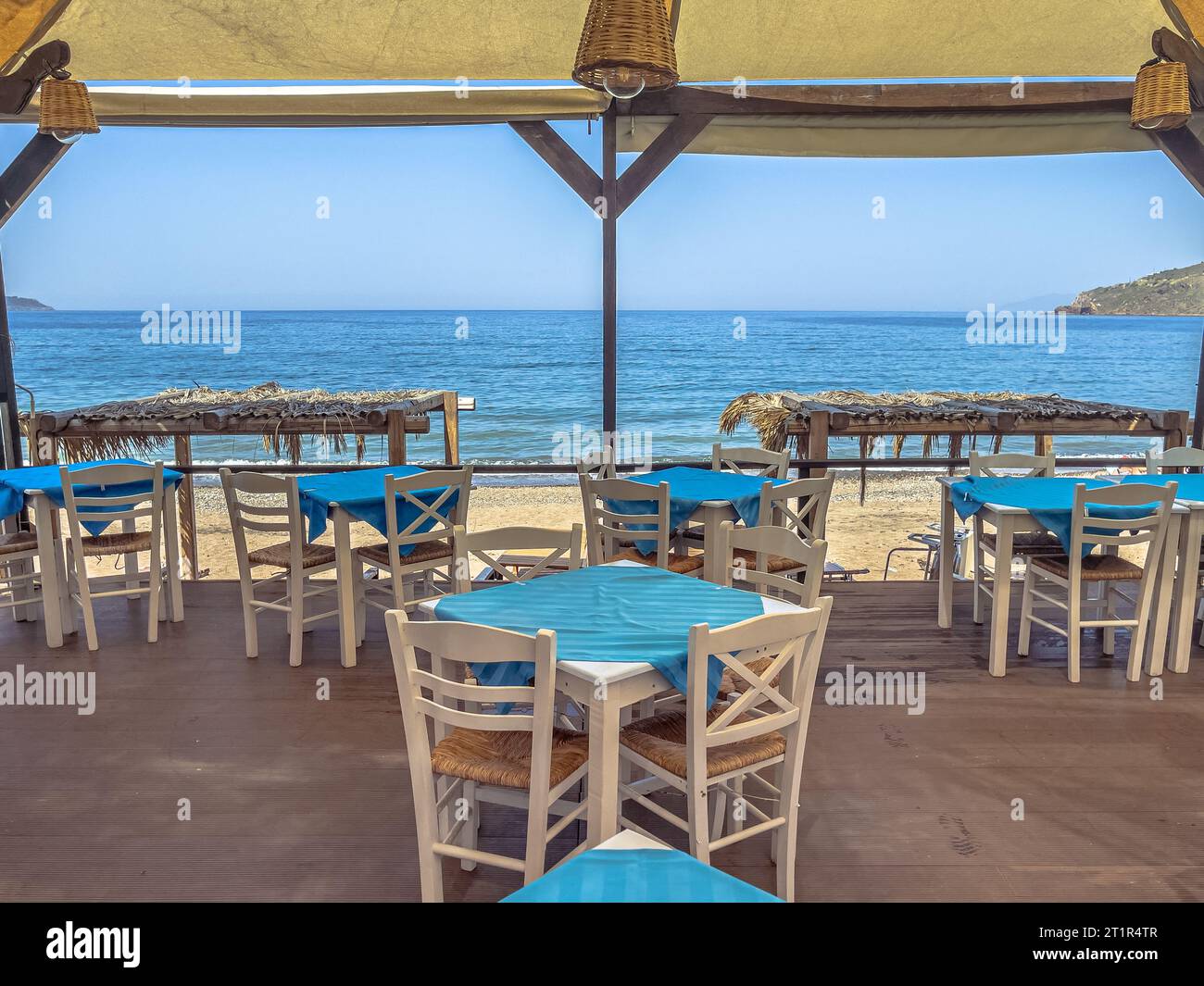 Terrasse mit Restaurant am Meer in Griechenland. Wunderschön gelegenes hölzernes Plattformdeck an der Promenade des Küstendorfes auf Lesbos Island. Griechenland. Stockfoto