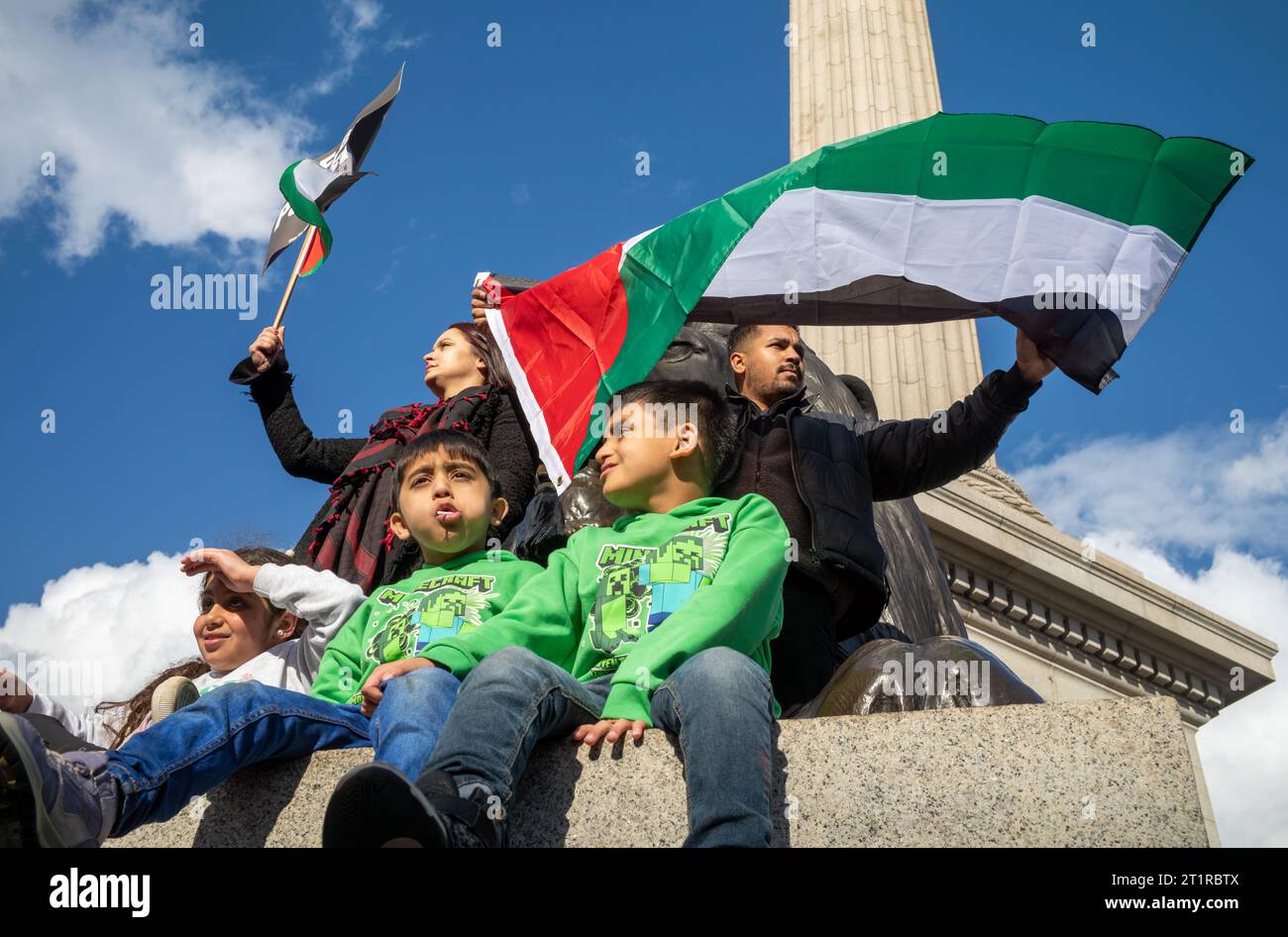 London, Großbritannien. 14. Oktober 2023: Muslimische Eltern schwenken mit ihren drei kleinen Kindern an der Basis von Nelsons Kolumne zur Unterstützung Palästinas und gegen Palästina Stockfoto