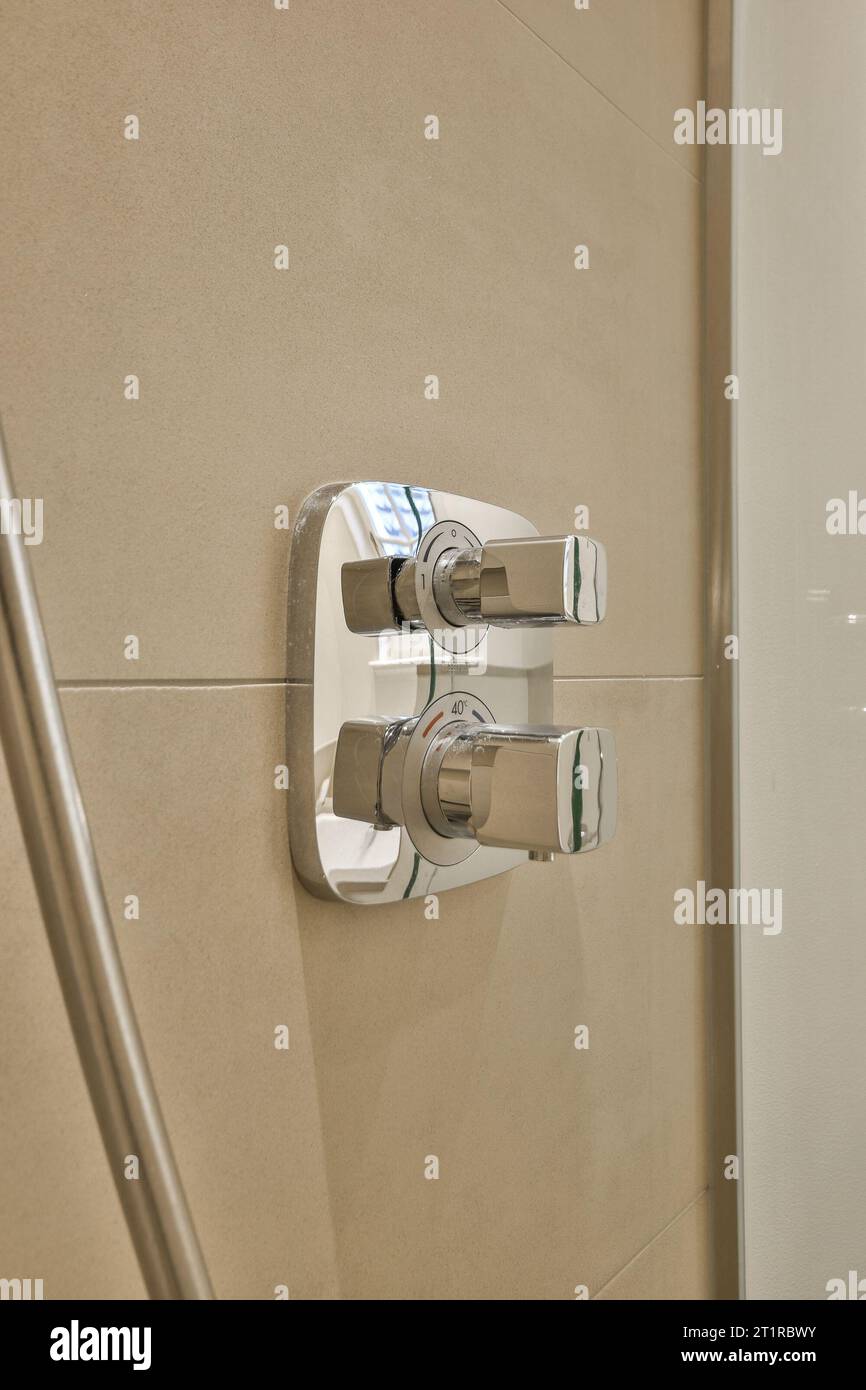 Ein Badezimmer mit Duschkopf und Hand im rechten Arm, auf der linken Seite der Wand Stockfoto