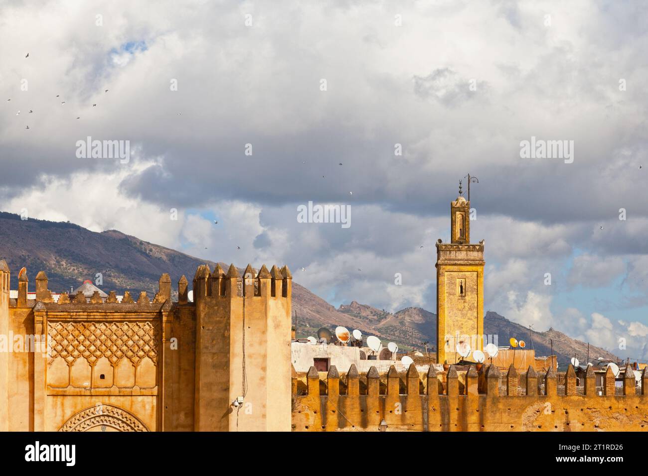 Befestigte Mauern von Fes mit teilweiser Sicht auf den Bab Chorfa und das Minarett der Kasbah an-Nouar Moschee im Feigenstein des Atlasgebirges. Stockfoto