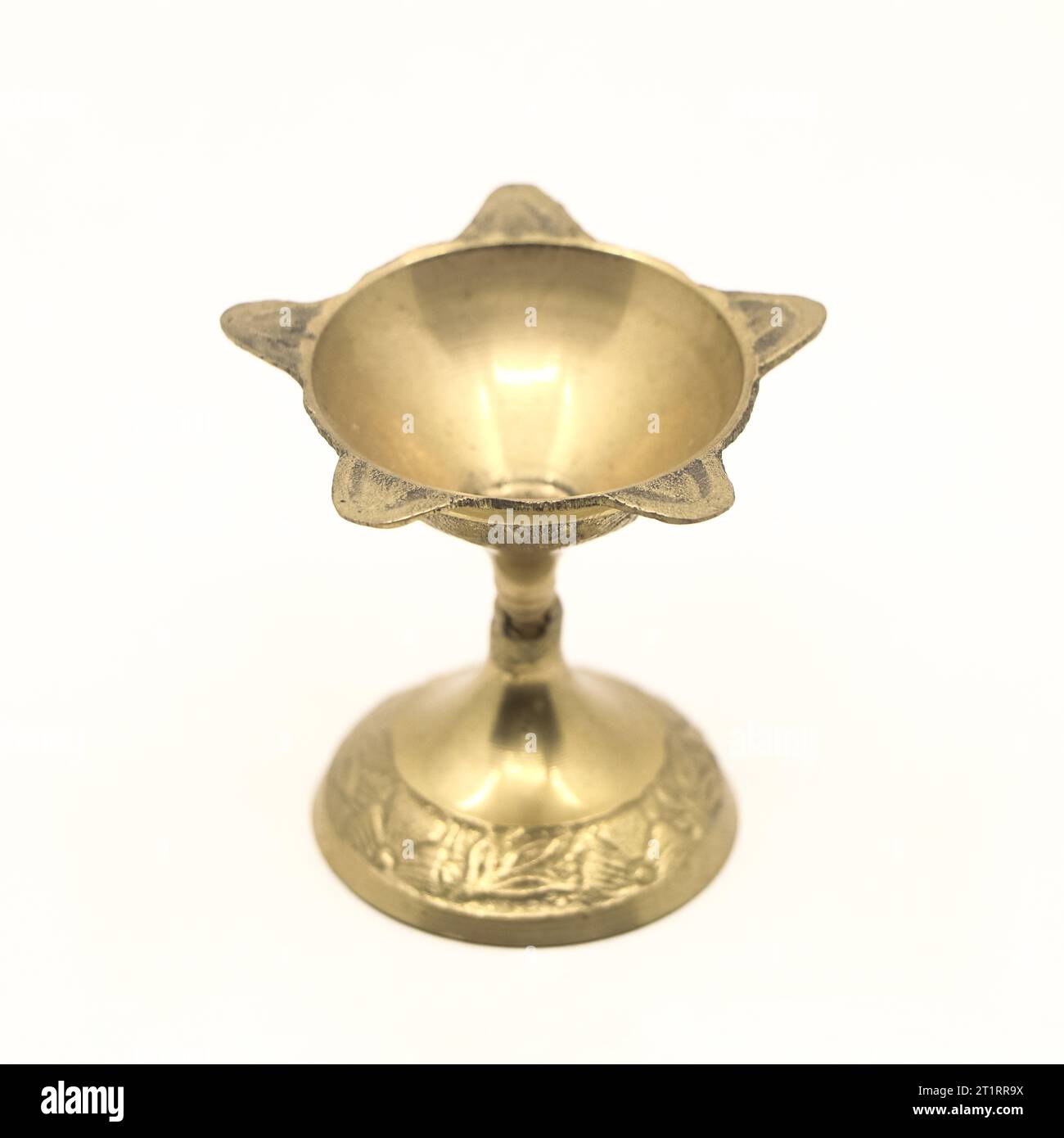 Ein sternförmiger Kerzenständer aus goldenem Messing, der für aarti-Gottesdienste in Tempelzeremonien isoliert verwendet wird Stockfoto