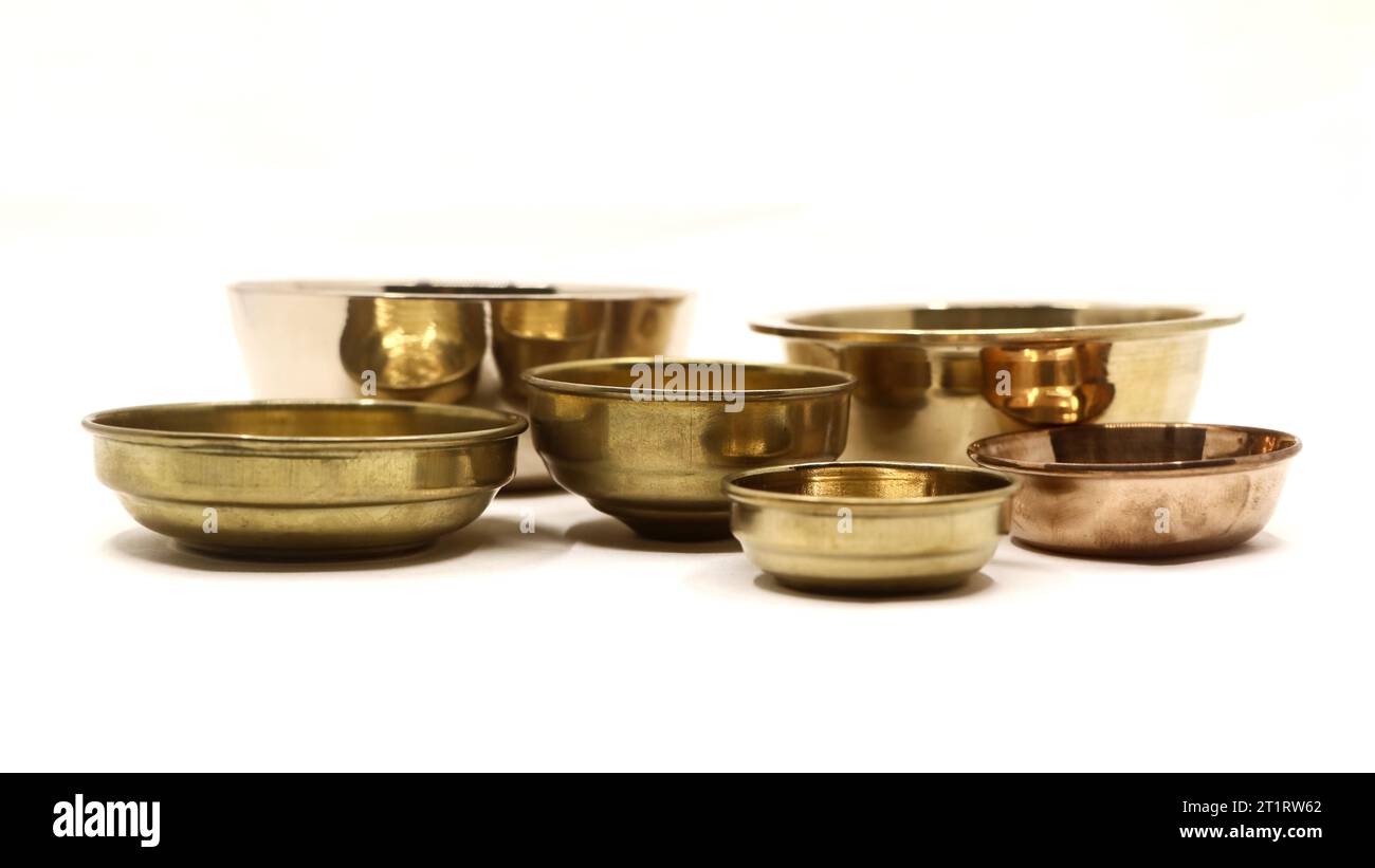 Nahaufnahme von alten antiken goldenen Schüsseltellern, die in einer Luxusküche verwendet wurden, isoliert auf einem weißen Hintergrund Stockfoto