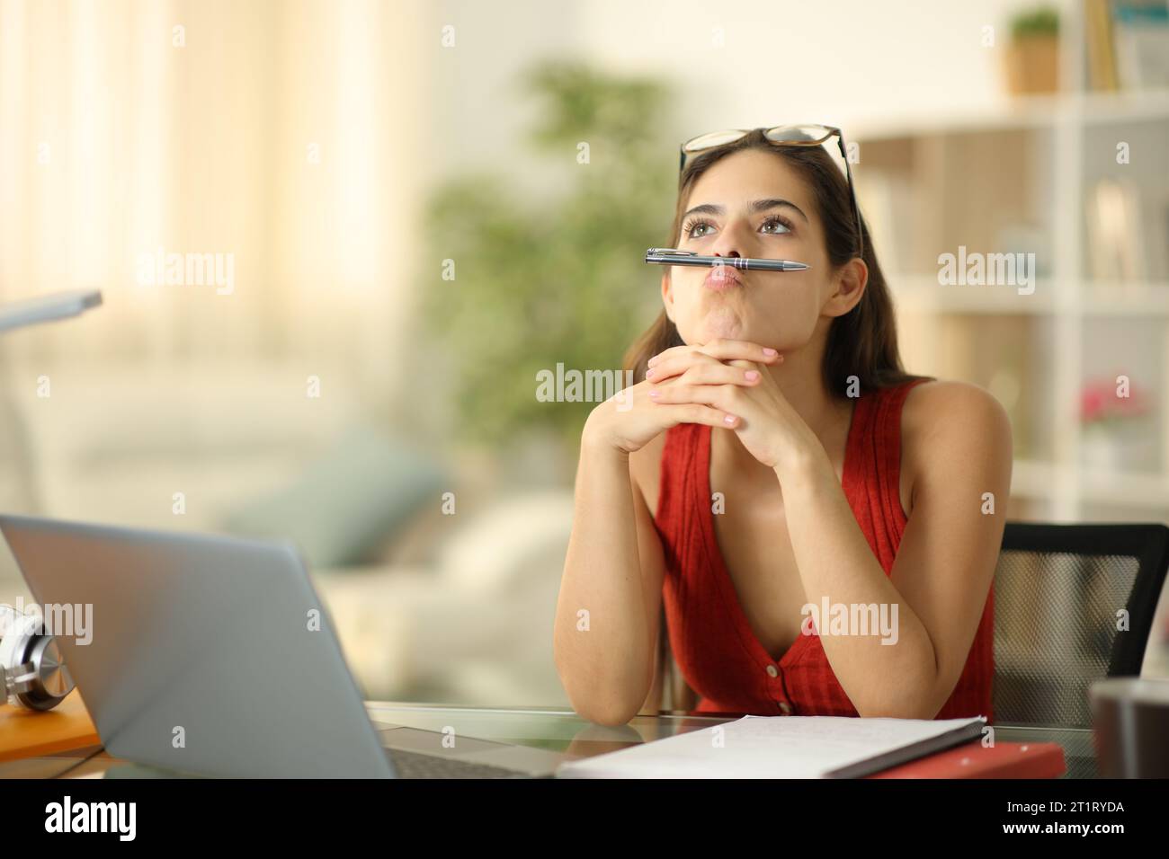 Gelangweilter Student mit Laptop verschwendet Zeit zu Hause zu sitzen Stockfoto