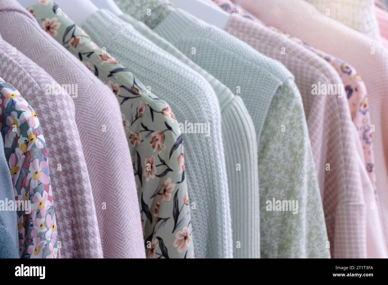 Modekleidung auf Kleiderständer Nahaufnahme Regenbogenfarbe Auswahl Damenbekleidung auf Kleiderbügeln im Kleiderschrank Sommerhaus Garderobe. Stockfoto