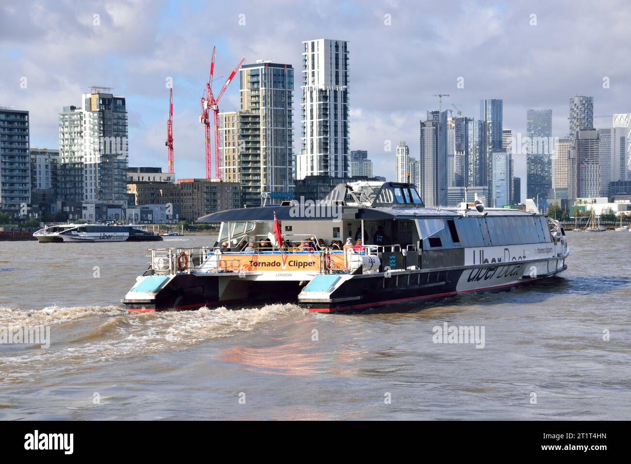 Uber-Boot mit dem Busschiff Tornado Clipper auf dem Thames Clipper verlässt den Pier Royal Wharf mit einer Verbindung in Richtung Westen nach London. Stockfoto