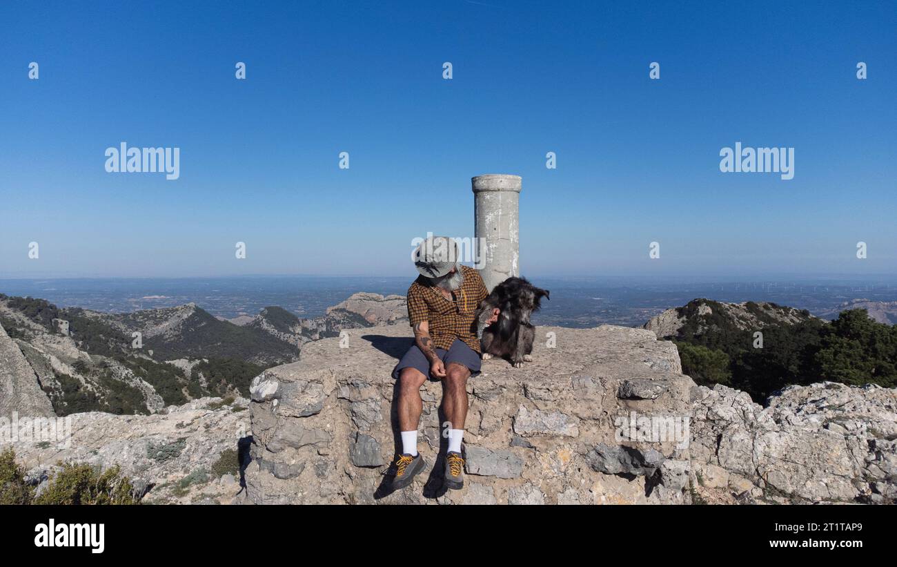 Ein Wanderer auf einem Berg mit seinem Haustier. Outdoor-Aktivitäten. Reisen Sie mit Hund Stockfoto