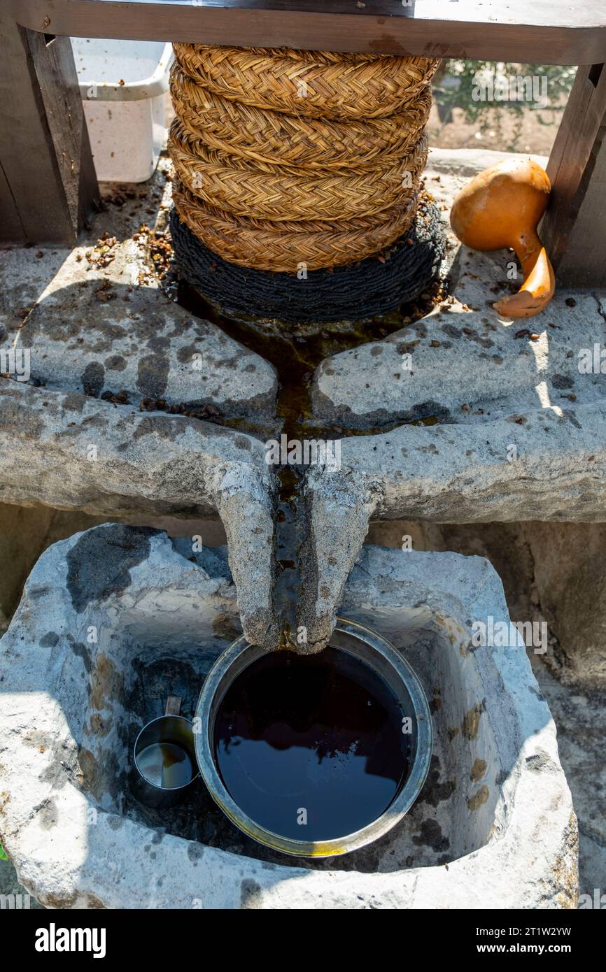 Olivenöl tropft aus einer traditionellen Olivenölpresse im Dorf Amargeti, Republik Zypern. Stockfoto