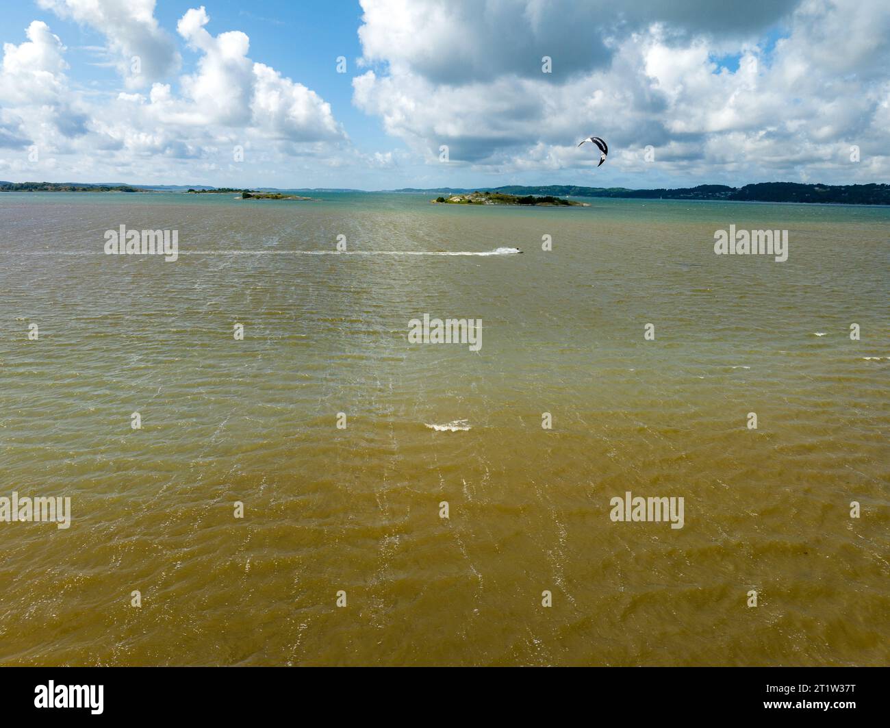 GETSKAR, SCHWEDEN - 30. JULI 2023: Kitesurfer fliegen über das Wasser am Getskar Surfspot an der Westküste Schwedens. Stockfoto