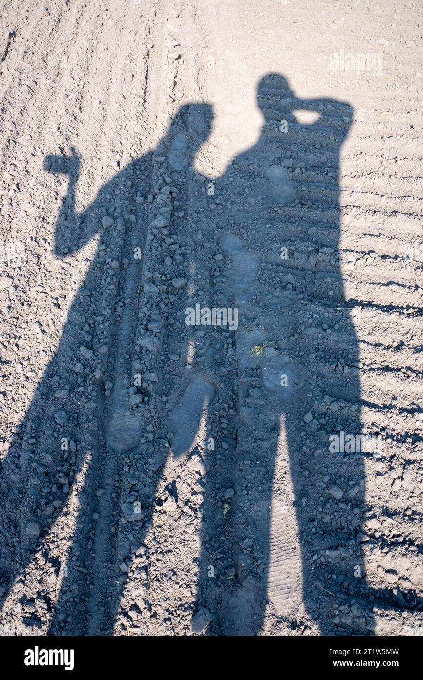 Schatten von zwei Personen auf frisch gepflügtem Boden Stockfoto