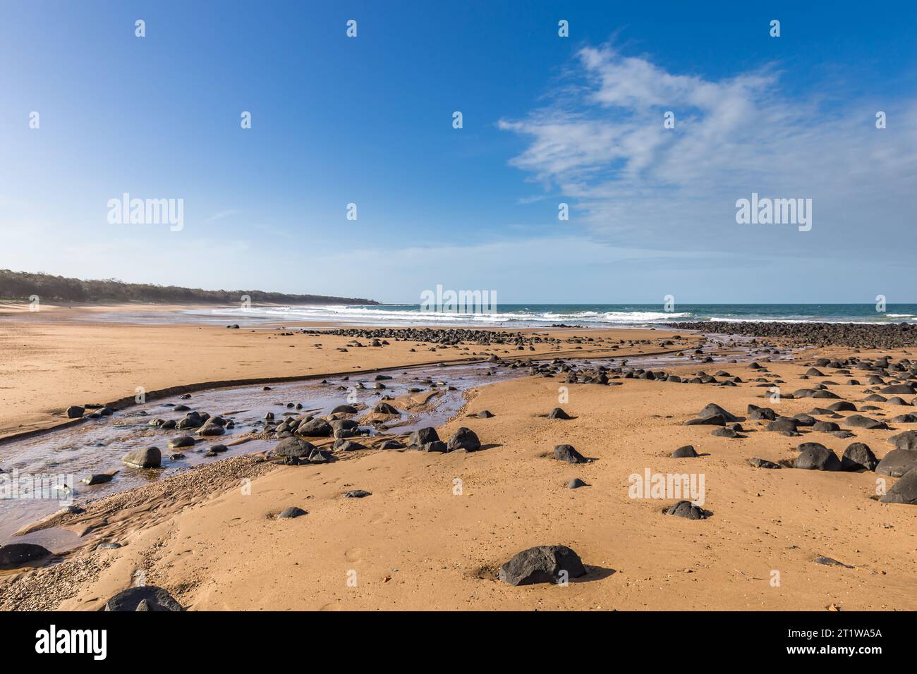 Strand mit Sand und kleinen Felsen am Mon Repos Walking Track in der Nähe von Bundaberg, Queensland, Australien. Stockfoto