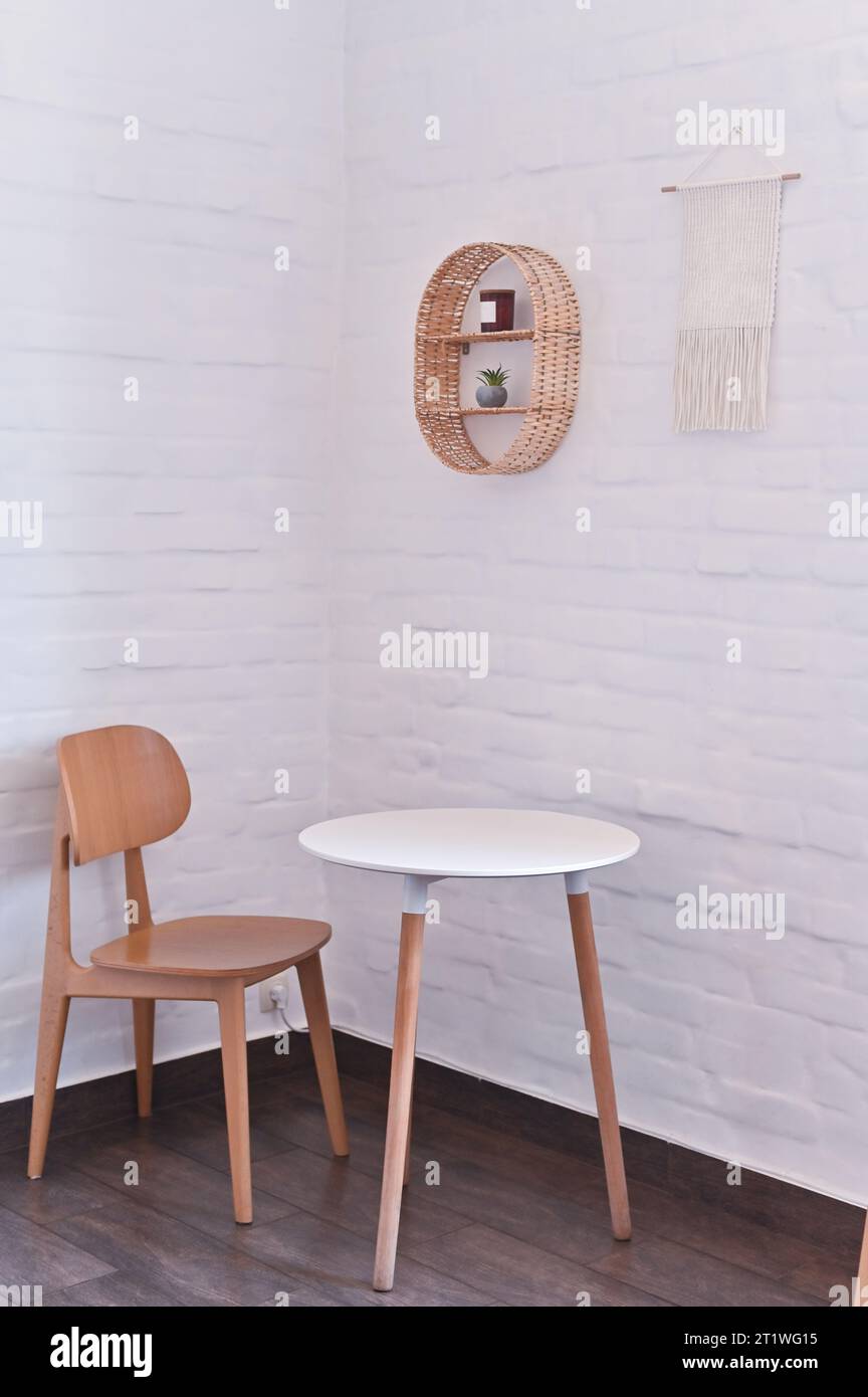 Ein Tisch und ein Stuhl in der Ecke des Zimmers. Vertikales Foto. Stockfoto