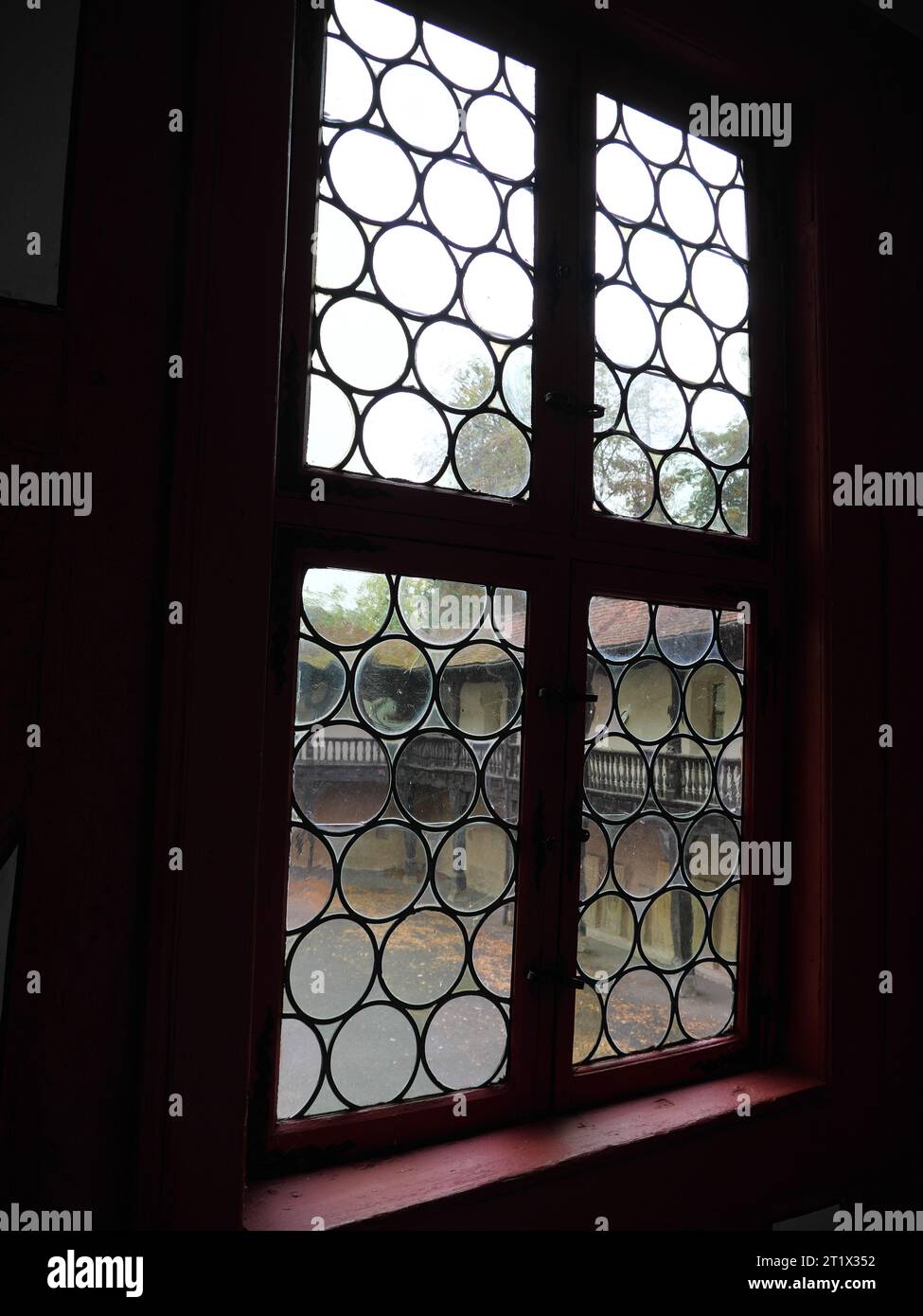 Blick durch bleiverglaste Fenster auf den Innenhof des Schlosses Götzenburg in Jagsthausen Stockfoto