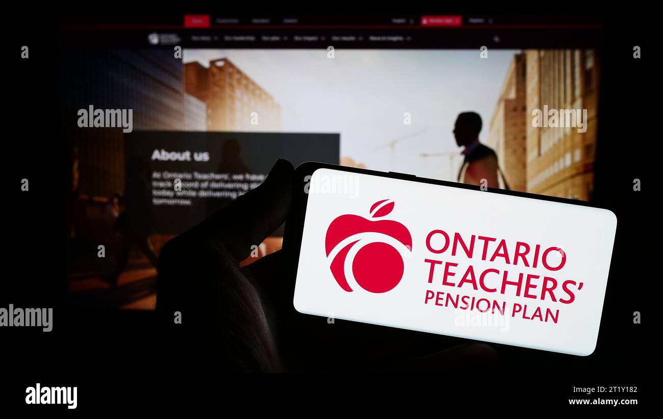 Person mit Smartphone und Logo der Organisation Ontario Teachers' Pension Plan Board (OTPP) vor der Website. Schwerpunkt auf dem Display des Telefons. Stockfoto