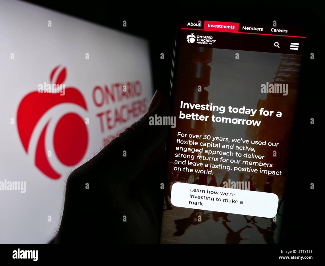 Person, die ein Smartphone mit Website der Organisation Ontario Teachers' Pension Plan Board (OTPP) mit Logo hält. Konzentrieren Sie sich auf die Mitte des Telefondisplays. Stockfoto