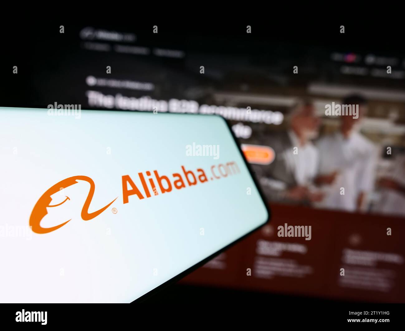 Mobiltelefon mit Logo der chinesischen B2B-E-Commerce-Plattform Alibaba.com vor der Business-Website. Fokus auf der linken Seite des Telefondisplays. Stockfoto