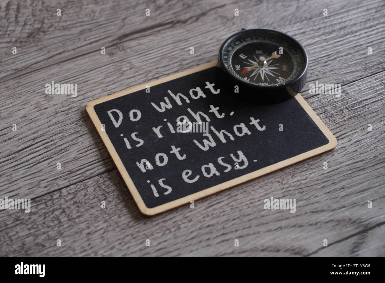 Nahaufnahme des Schwarzen Bretts mit Text: TUN SIE, WAS RICHTIG IST, NICHT, WAS EINFACH IST und Kompass. Moralisches Kompasskonzept Stockfoto