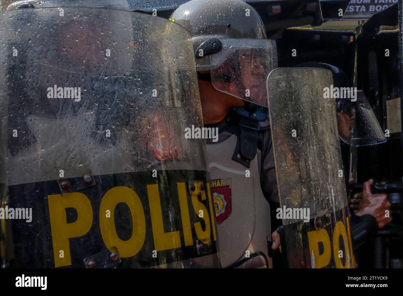 Polizeibeamte in Bogor City, Indonesien, tragen Helme und Schilde und bereiten sich darauf vor, während der Wahlsicherheit 2024 den Demonstranten der Simulation gegenüberzutreten Stockfoto