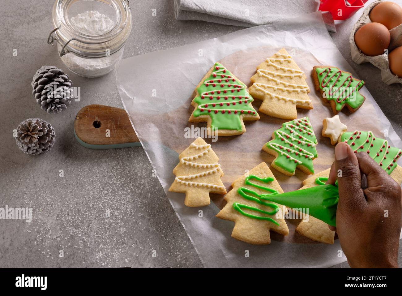 Die Hand der afroamerikanischen Frau, die weihnachtskekse mit Kopierraum dekoriert Stockfoto