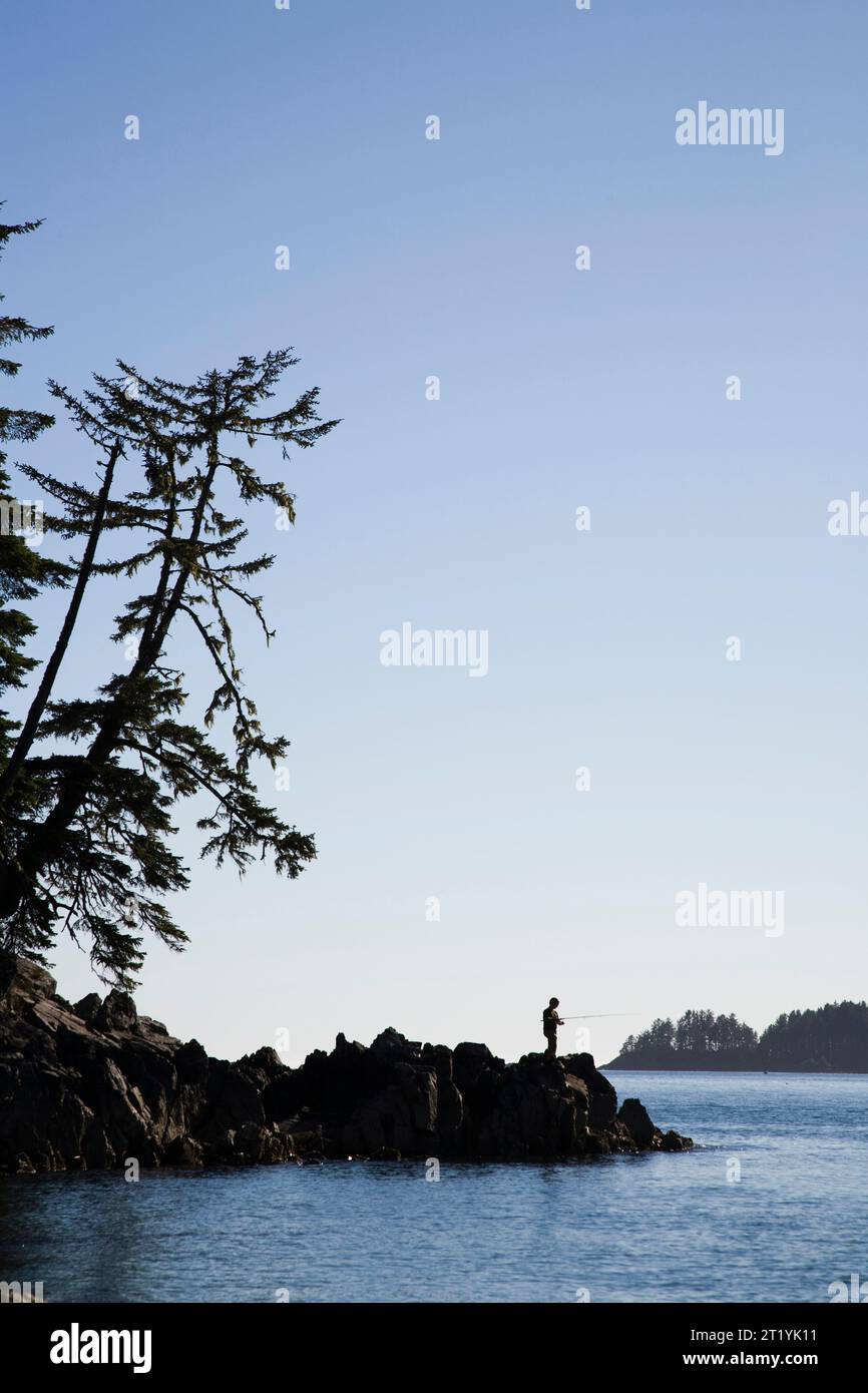 Vor der Küste von Vancouver Island fischt ein Mann vor einem blauen Himmel. Stockfoto