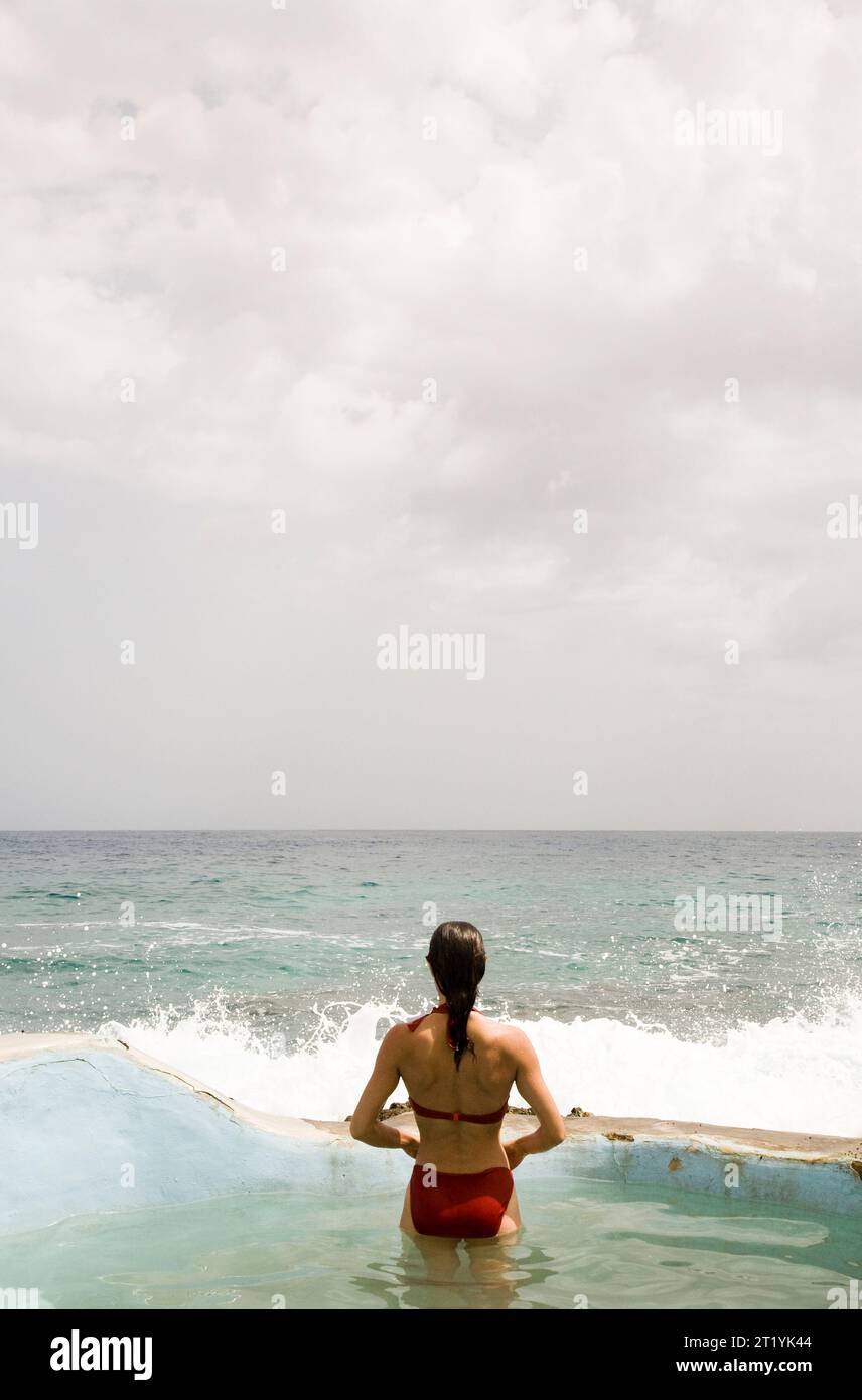 Eine Frau genießt einen kleinen Oceanside-Pool eine lokale, Bio-Spa-Resort. Stockfoto
