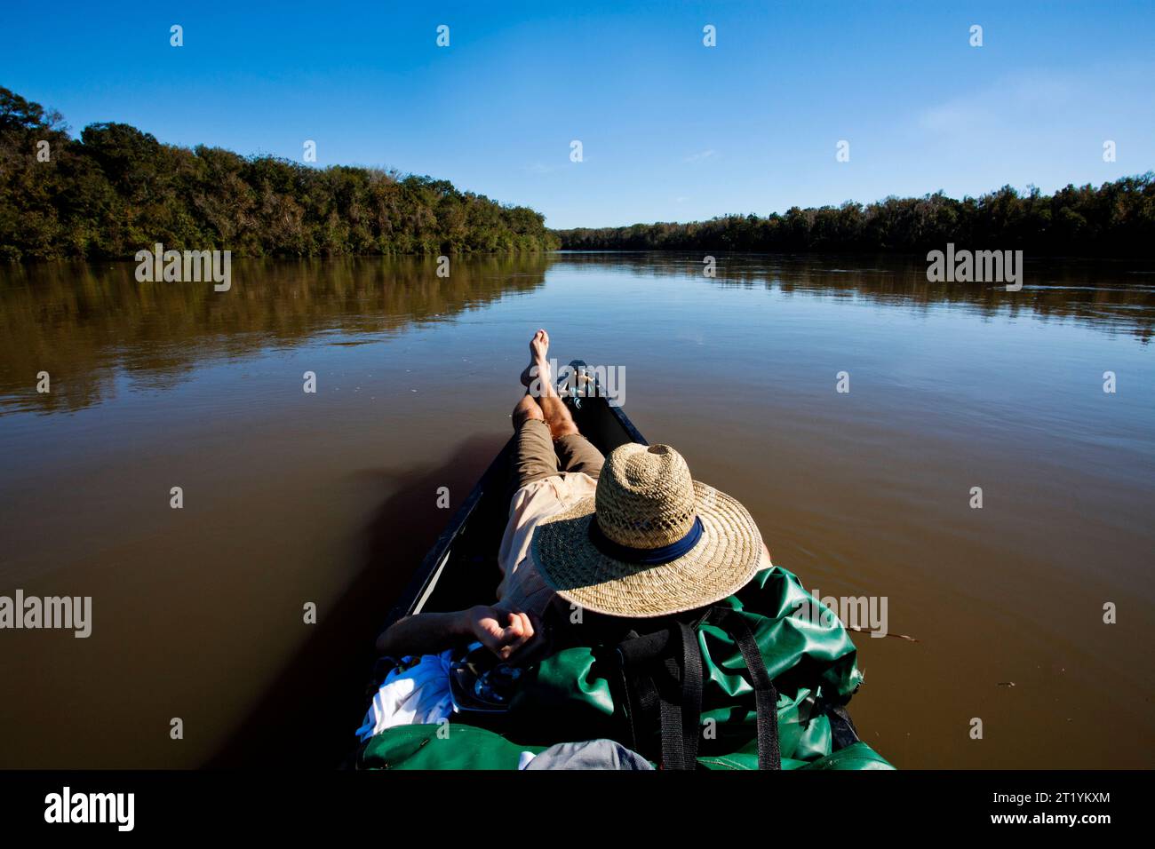 Ein Mann liegt vor seinem Kanu während seiner zweimonatigen Fahrt vom Quellgebiet des Chattahoochee River bis zur Mündung des Apalachicola River und der Apalachicola Bay in Florida Stockfoto