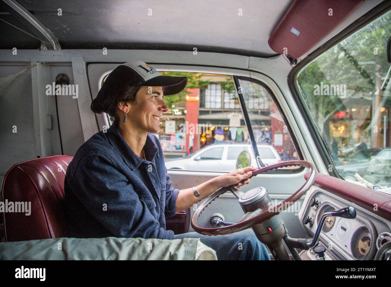 Eine Frau fährt einen Van durch Port Townsend, während sie sich auf das Rennen nach Alaska vorbereitet, ein 750 Meilen langes, nicht motorisiertes Boot-Rennen von Port Townsend, WA nach Ketchikan, Alaska. Stockfoto