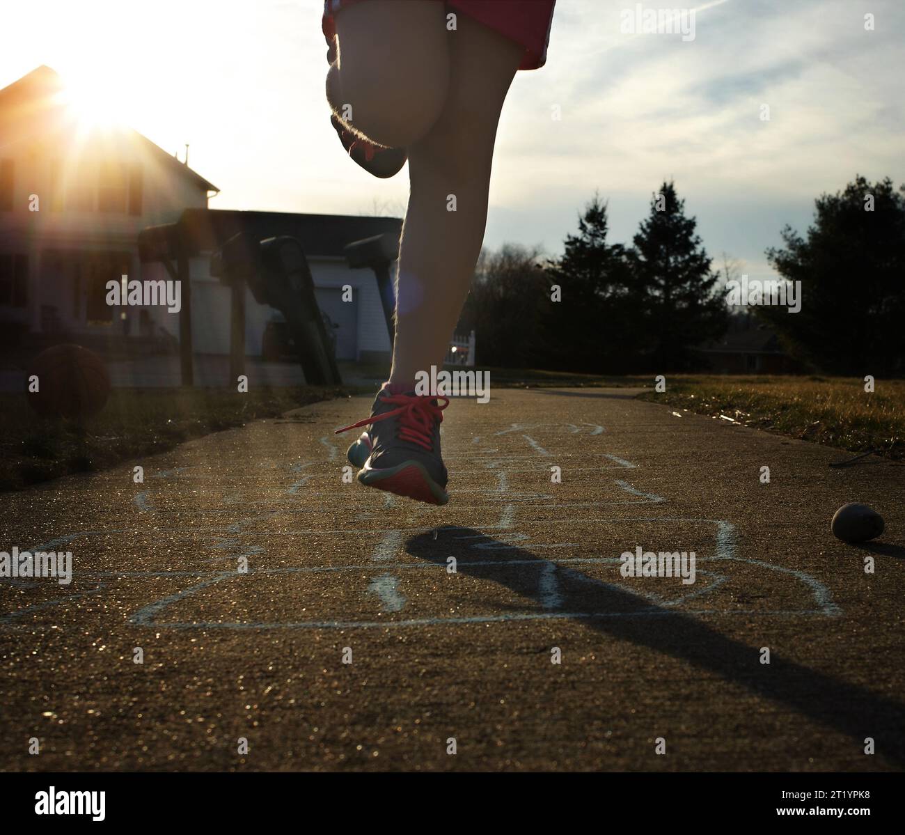 Kleines Kind, das an sonnigen Tagen im Freien HopfenScotch spielt Stockfoto