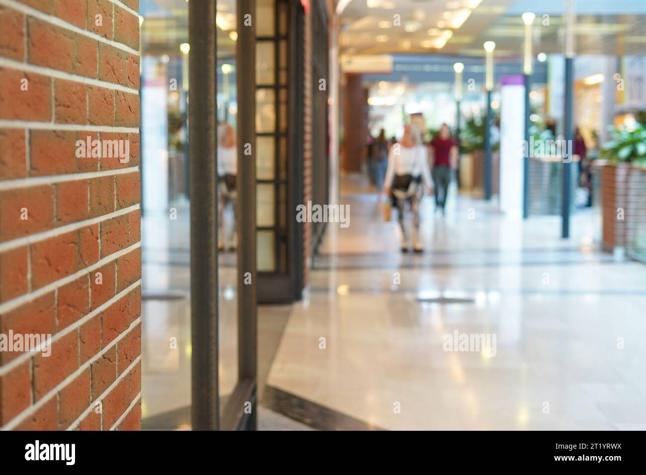 Abstraktes, unscharfes Luxus-Einkaufszentrum und Einzelhandelsgeschäft mit Backsteinwand als Hintergrund Stockfoto
