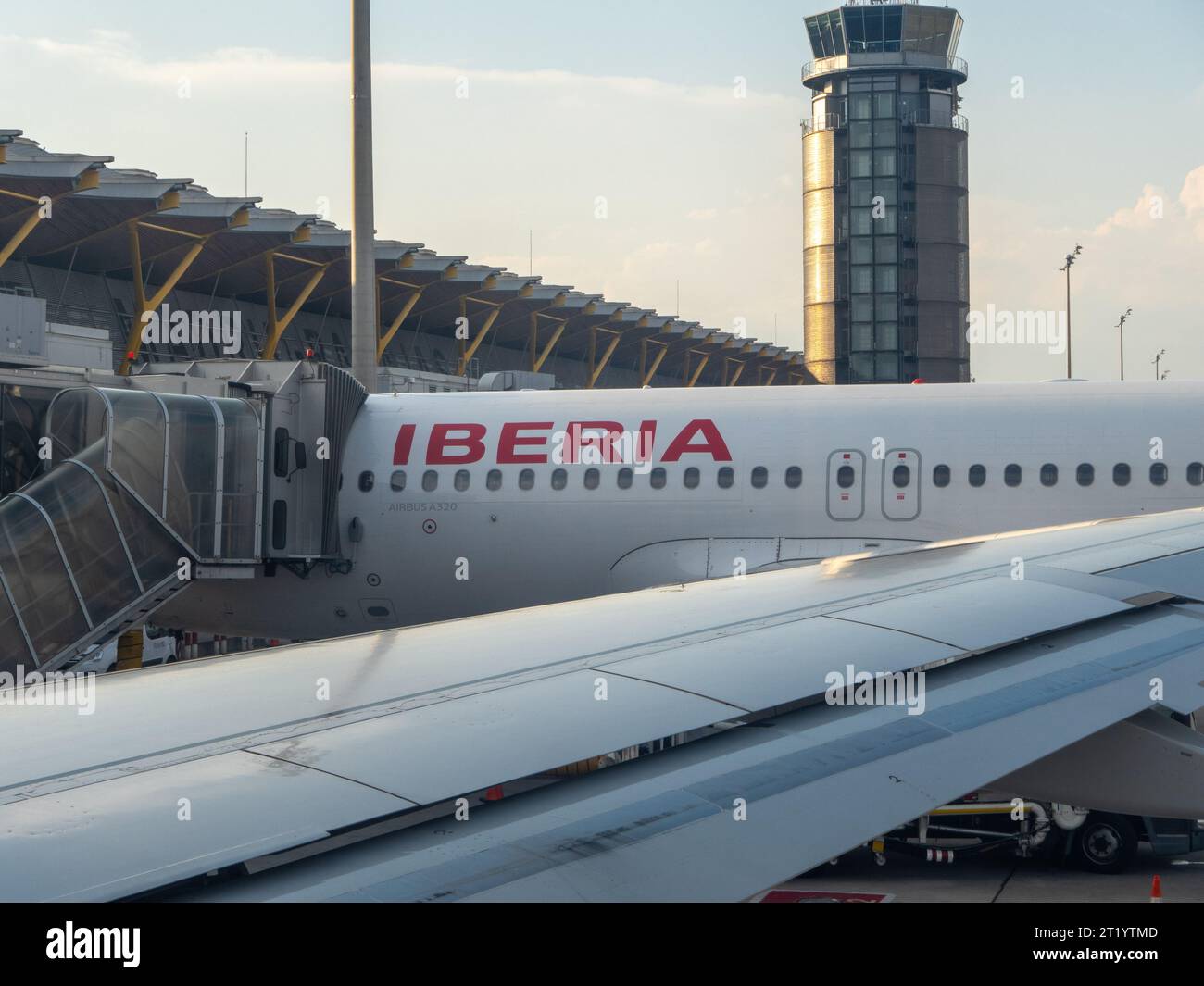 Santiago de Compostela, Spanien - 17. Juni 2023: Teile eines IBERISCHEN Flugzeugs vor dem Turm und dem Abflugstor des lokalen Flughafens. IBERIA i Stockfoto