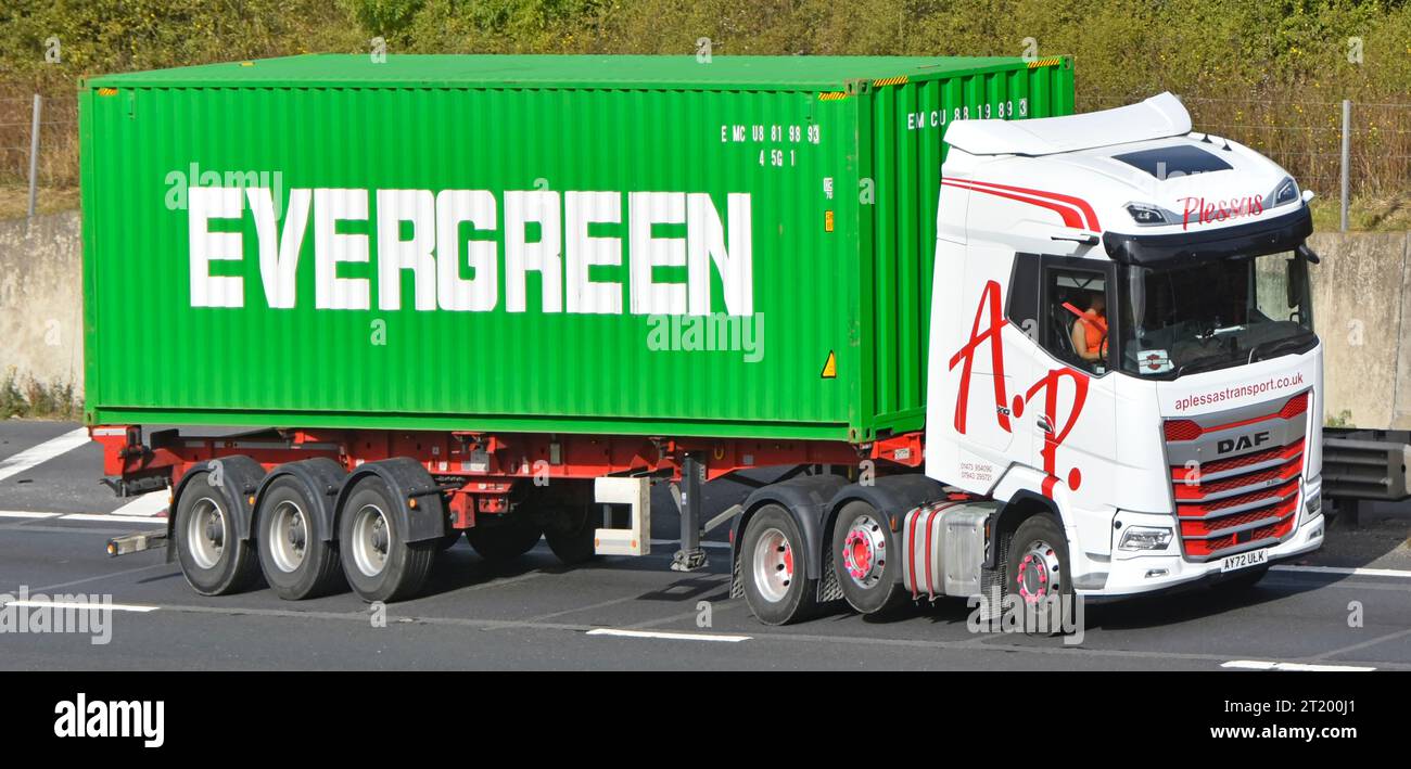 Transportcontainer der Marke EVERGREEN auf Sattelaufliegern, die von einem Transportunternehmen gezogen werden. Weißer DAF-Großtransporter lkw mit Lastkraftwagen, der auf der M25 UK-Autobahn fährt Stockfoto