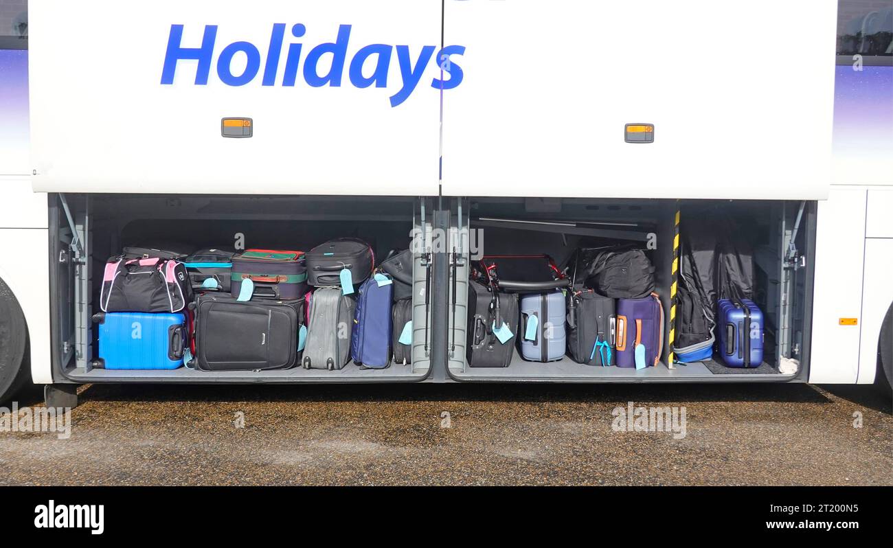 Crusader Holidays Bus Nahaufnahme Seitenansicht offenes Staufach Urlauber Koffer Gepäck ordentlich gestapelt vor der Abreise England Großbritannien Stockfoto
