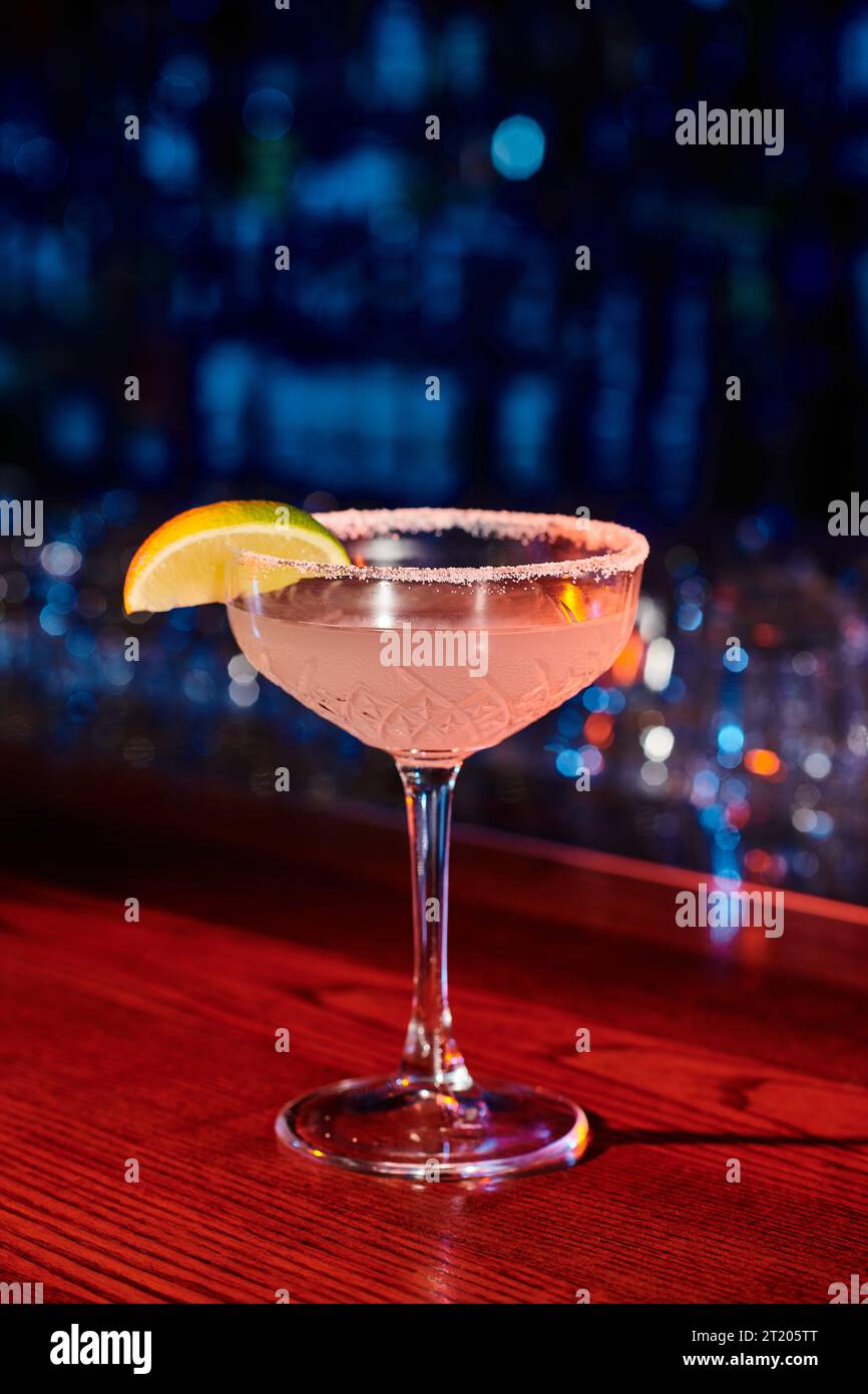 Durstlöschender eiskalter Margarita-Cocktail mit Limette mit Barhintergrund, Konzept Stockfoto