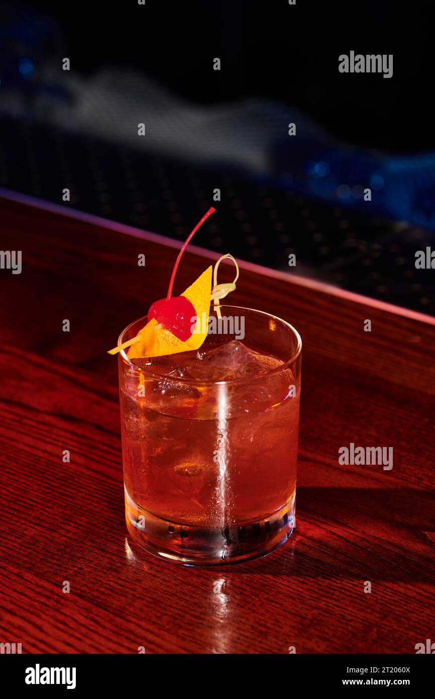 Eiskaltes, raffiniertes Glas negroni, dekoriert mit Kirsche an der Bar, Konzept Stockfoto