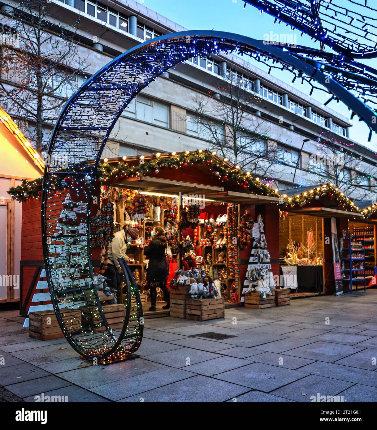 Weihnachtslichter verleihen den kleinen Holzständen auf Plymouth’s Christmas Market im Jahr 2021 Wärme, Masken zeigen COVID Is about. Stockfoto