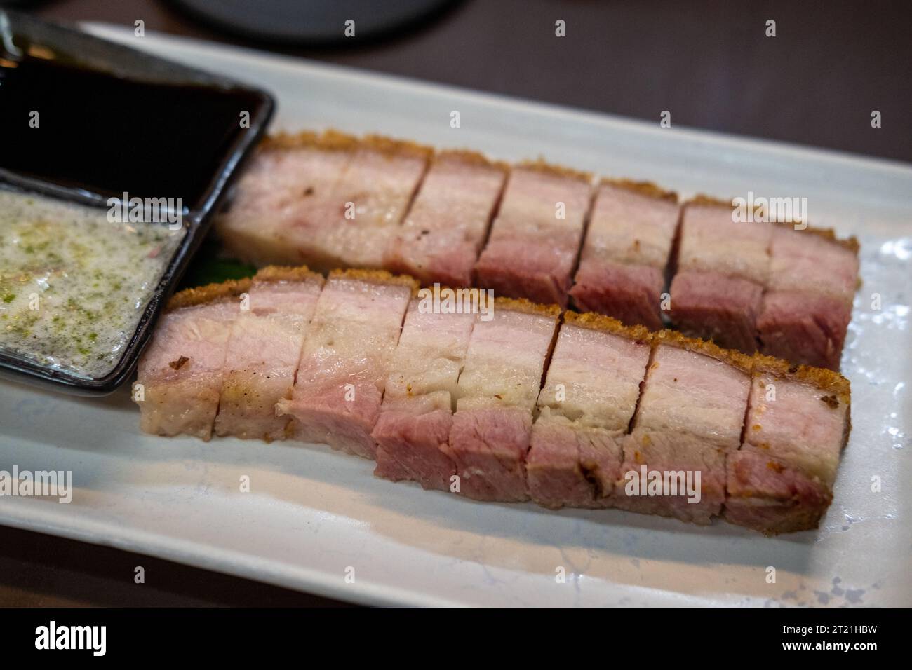 Gebratenes, knuspriges Schweinefleisch, serviert auf einem Teller, fertig zum Essen Stockfoto