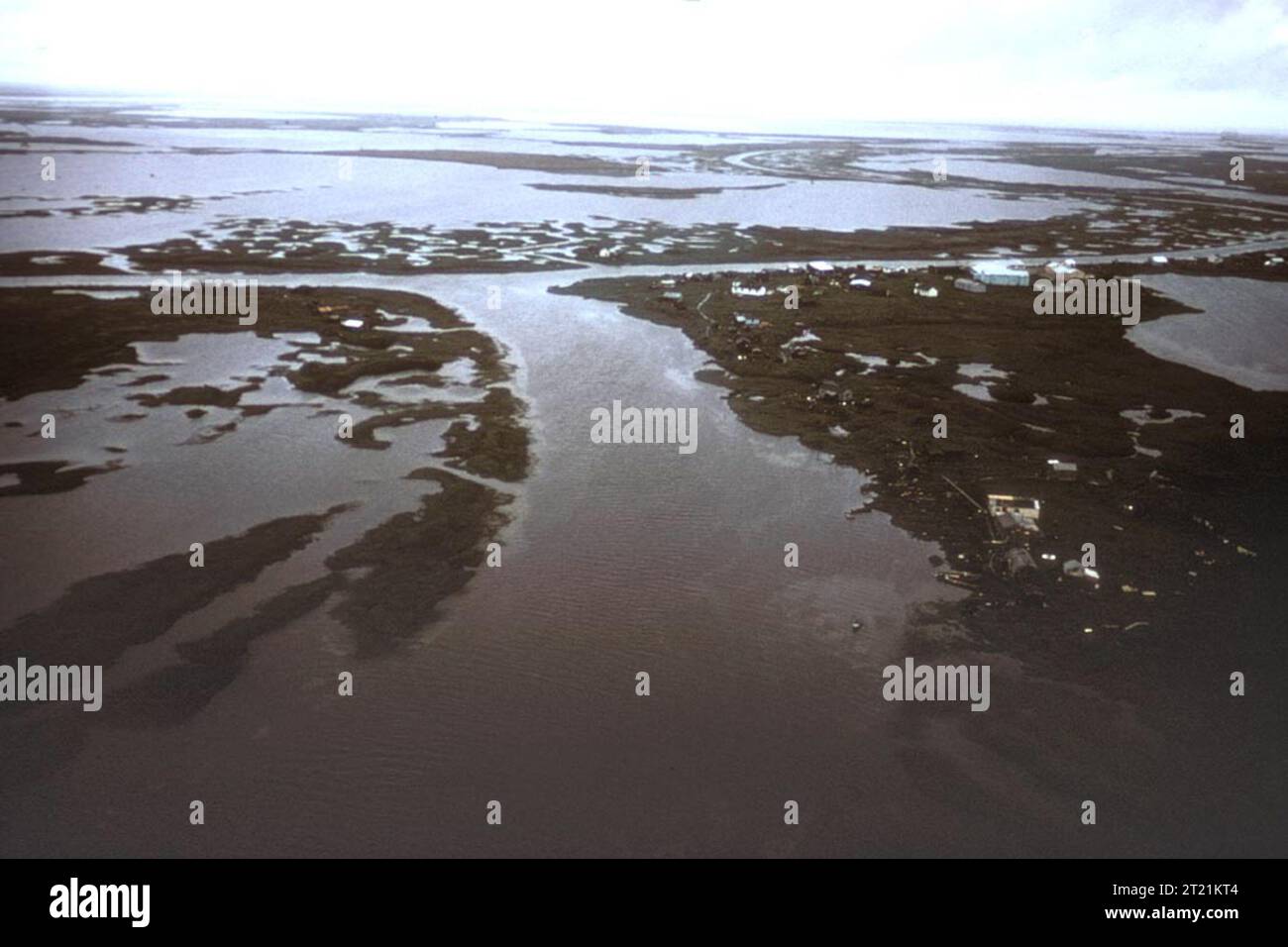 Ein Blick aus der Vogelperspektive auf ein Dorf der Ureinwohner Alaskas im Yukon Delta National Wildlife Refuge. Das Dorf liegt in der Wildnis Alaskas, wo das umliegende Ökosystem sowohl Menschen als auch Wildtiere unterstützt. Dieser Bereich ist für die traditionelle Lebensweise und die Nutzung der natürlichen Ressourcen von entscheidender Bedeutung. Stockfoto