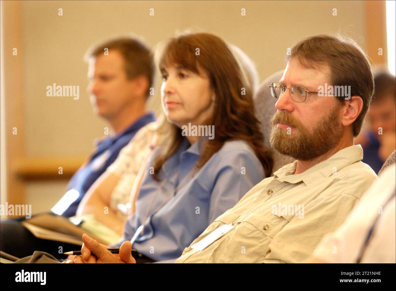 Drei Personen hören während des FWS/USGS Future Challenges Workshops, der im stattfand, aufmerksam einem Sprecher zu Stockfoto