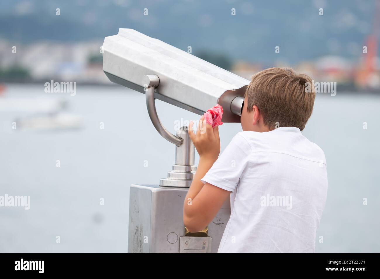 Der Junge schaut auf die Aussichtsplattform in einem touristischen Handteleskop. Stockfoto