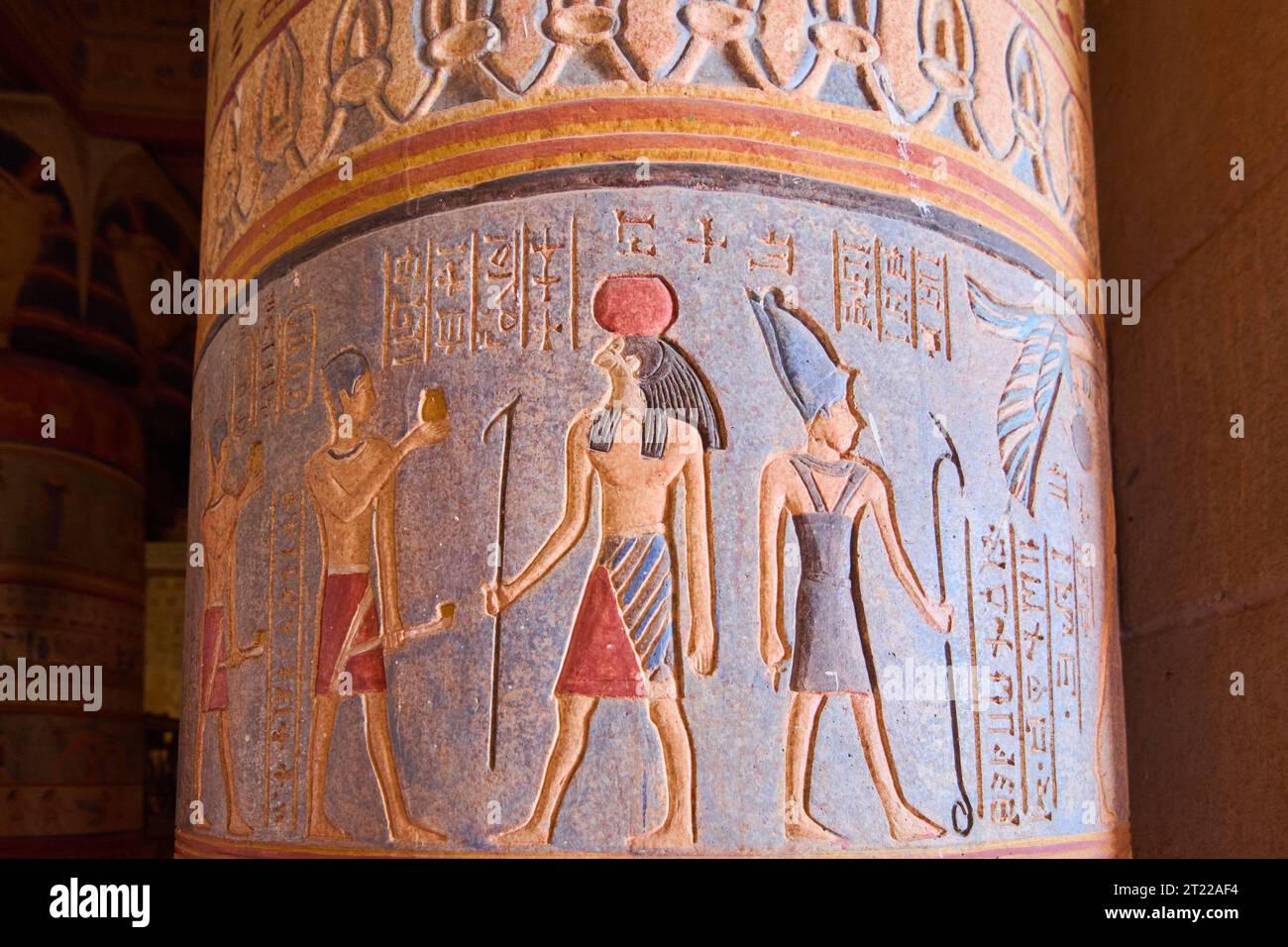 Nahaufnahme einer ägyptischen Säule mit Hieroglyphen und drei sehr bunten Figuren auf blauem Hintergrund. Stockfoto