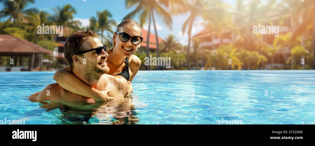 Lächelndes, glückliches Paar, das sich im Pool des Resorts amüsiert. Sommerurlaub, Kurzurlaub. Banner mit Kopierbereich Stockfoto