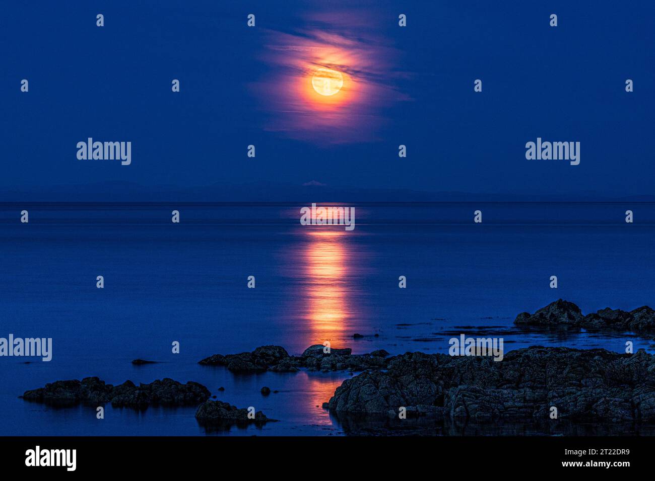 Der Supermond (ein blauer Mond) am 30/8/2023, der über der Isle of Arran von der Kintyre-Halbinsel aus gesehen aufsteigt Stockfoto