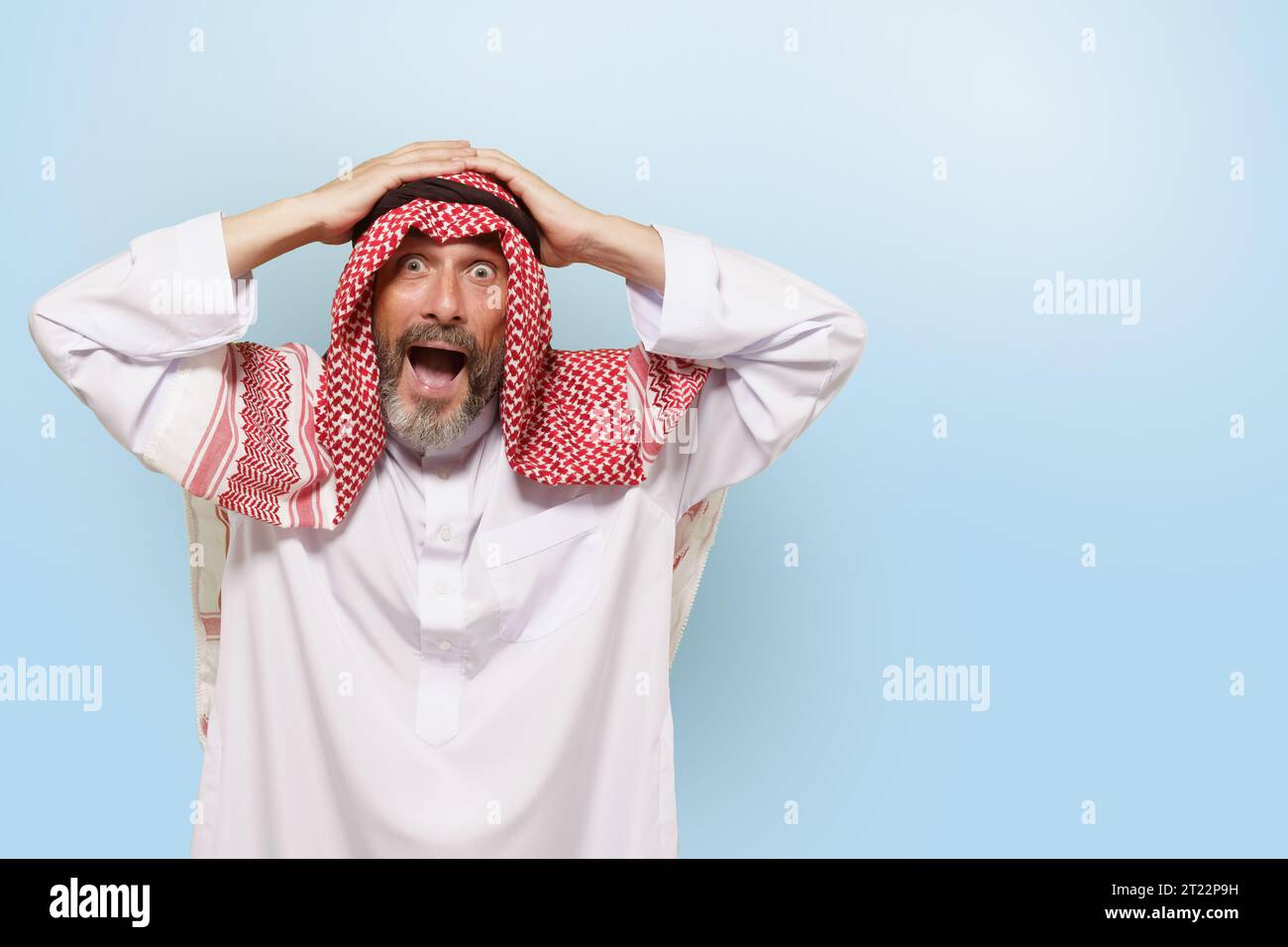 Aufgeregter arabischer Mann aus dem Nahen Osten oder Muslim, in traditioneller Kleidung keffiyeh-Kopftuch, mit einem Lächeln am Kopf. Freude und Stolz des islamischen Volkes, kulturelle Vielfalt und reiche Traditionen der ethnischen Gruppe. Hochwertige Fotos Stockfoto