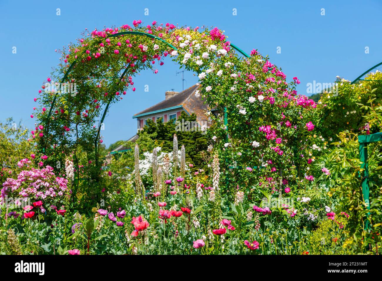 Rosenbögen und farbenfrohe Sommerblumenränder in Giverny, dem Garten des französischen impressionistischen Malers Claude Monet, Normandie, Nordfrankreich Stockfoto