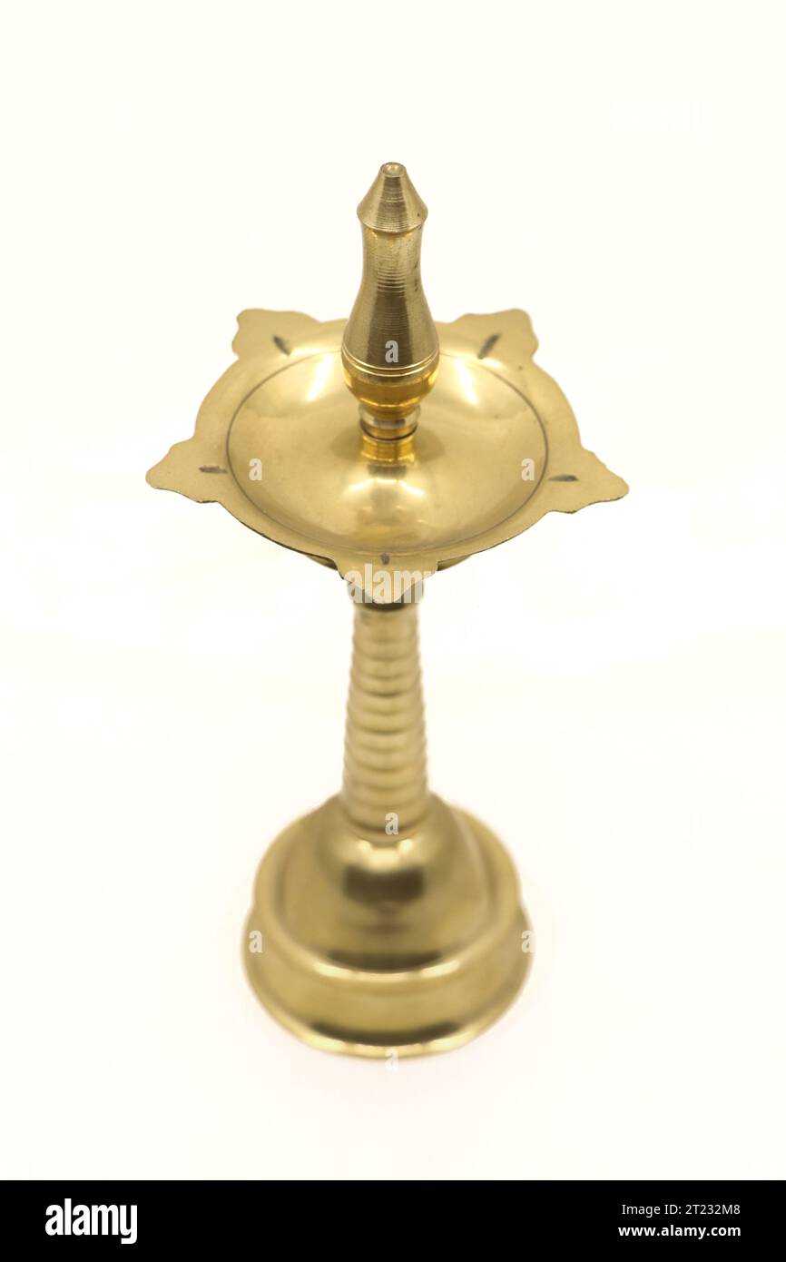 Alte Vintage-Öldochtlampe oder Vilakku aus goldenem Messing, die in Tempeln und Gotteshäusern traditionell isoliert auf weißem Hintergrund verwendet wird Stockfoto