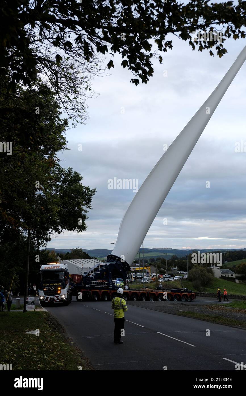 Selkirk, Großbritannien. Oktober 2023. Ein Windturbinenschaufel auf dem Weg zu einer neuen Anlage in der Nähe von Hawick, ein Verkehrskonvoi machte die Reise von einem Haltepunkt auf der A68 bei St Boswells nach Selkirk auf der A699, dann navigierte er an einer ungünstigen Kreuzung an der A7 Selkirk, auf der A7 nach Süden hält sie über Nacht an, bevor sie weiter zum Ziel am Windpark Pines Burn geht. Es handelt sich um ein 36-MW-Projekt ohne Subventionen für Onshore-Windenergie, das sich auf dem Harwood Estate in der Nähe der Bonchester Bridge und Hawick in den schottischen Grenzen befindet. (Quelle: Rob Gray/Alamy Live News Stockfoto