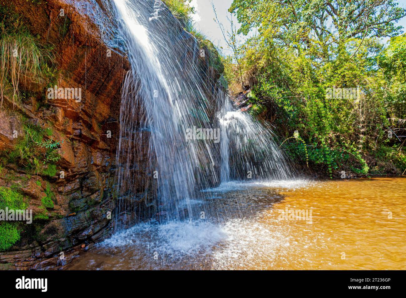 Wasserfall zwischen Felsen und Wald im Muaimii-Naturschutzgebiet im Bundesstaat Minas Gerais an einem sonnigen Tag Stockfoto