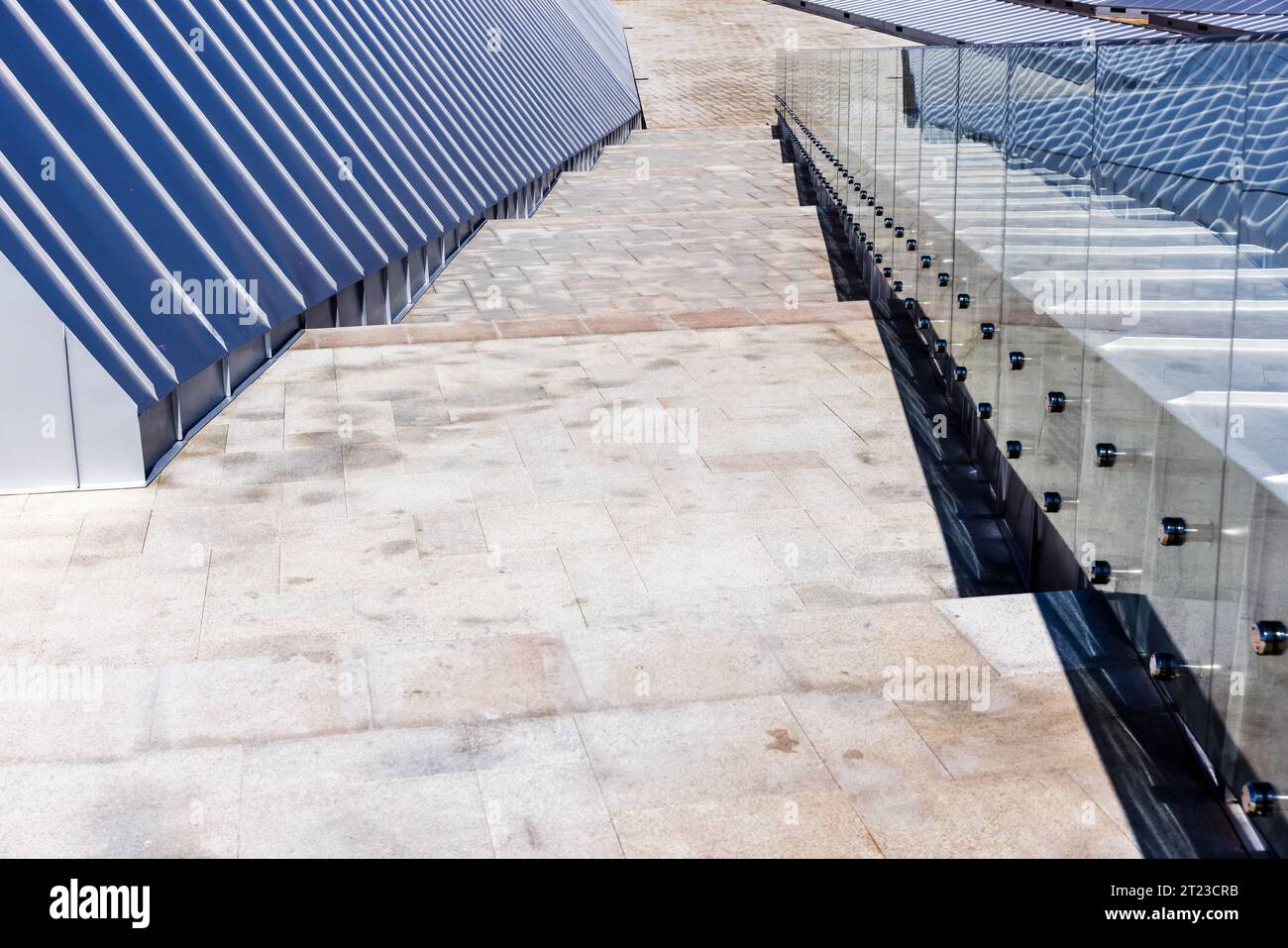 Glänzendes Dach aus Edelstahlplatten, Geländer und Steintreppe nach unten. Hintergrundfoto abstrakter moderner Architektur Stockfoto
